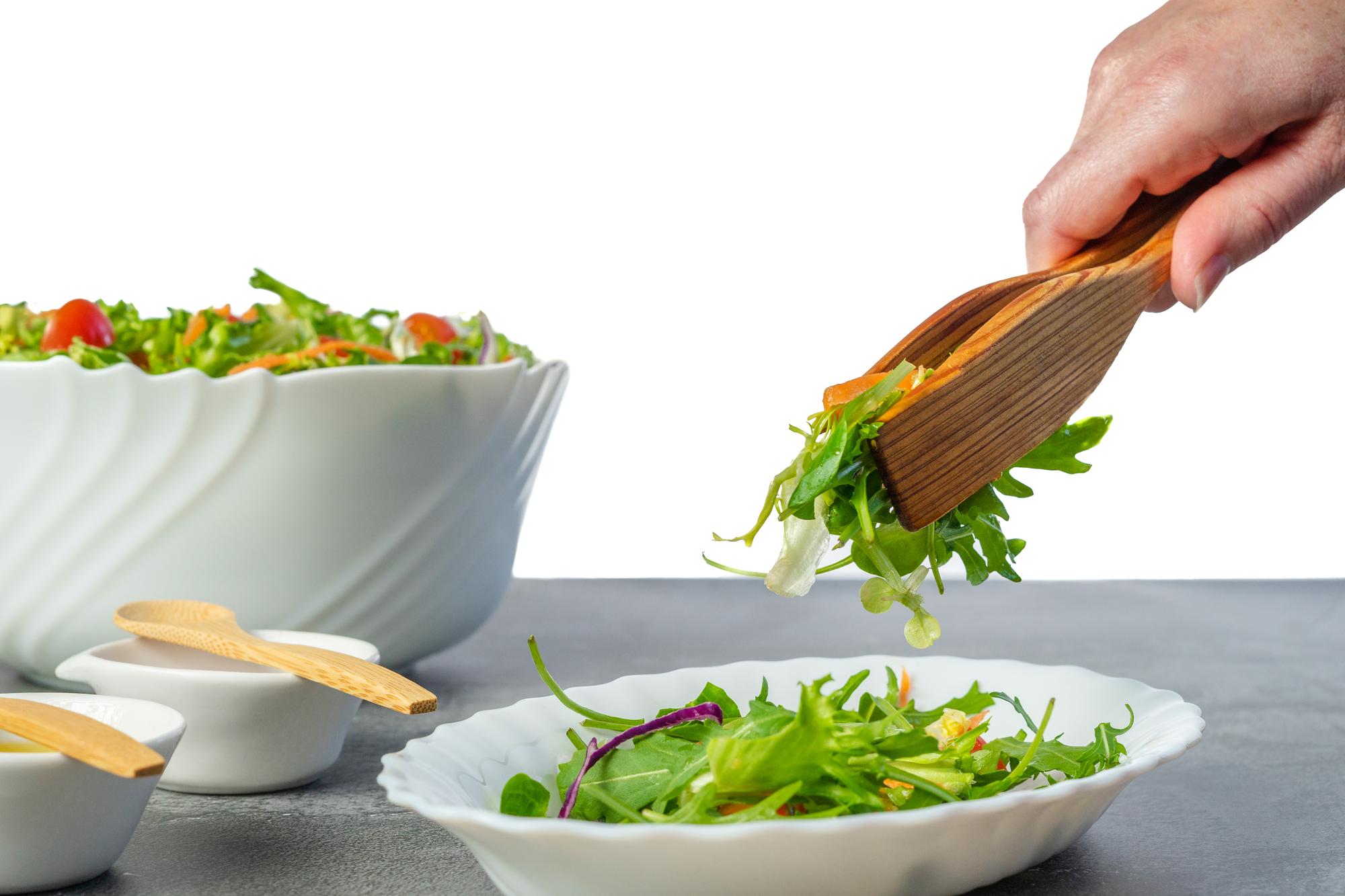 Chef hands preparing a colorful salad in a bright kitchen